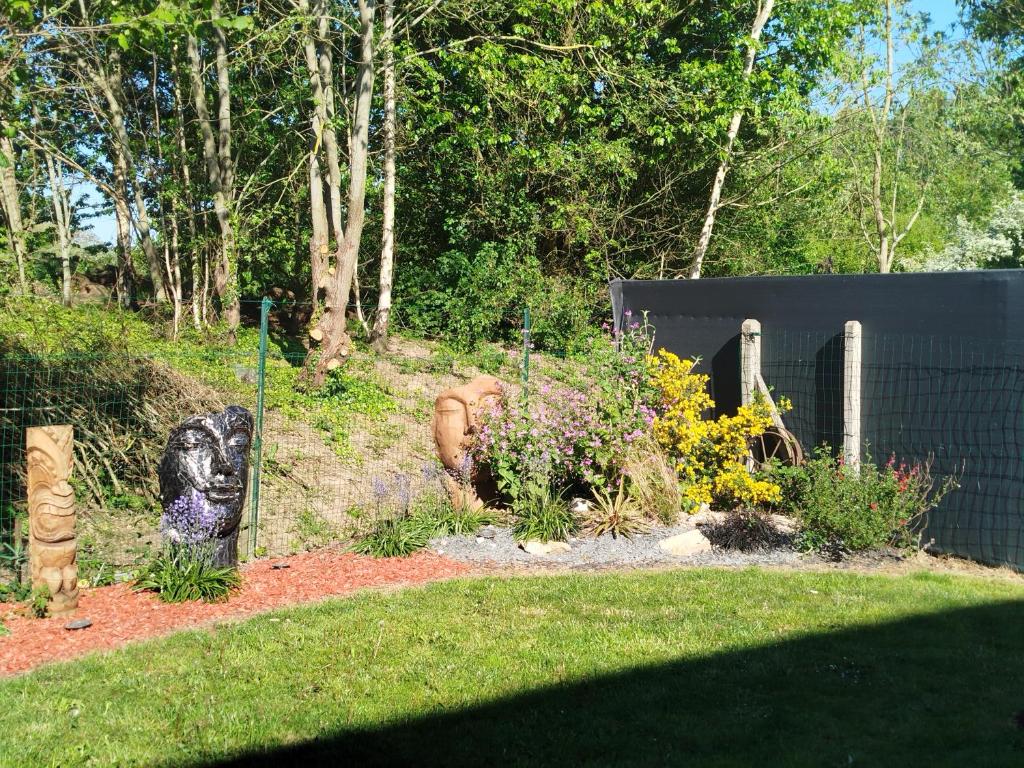 a garden with a statue of a bear in a yard at maison cosy des 3 etangs in Mametz