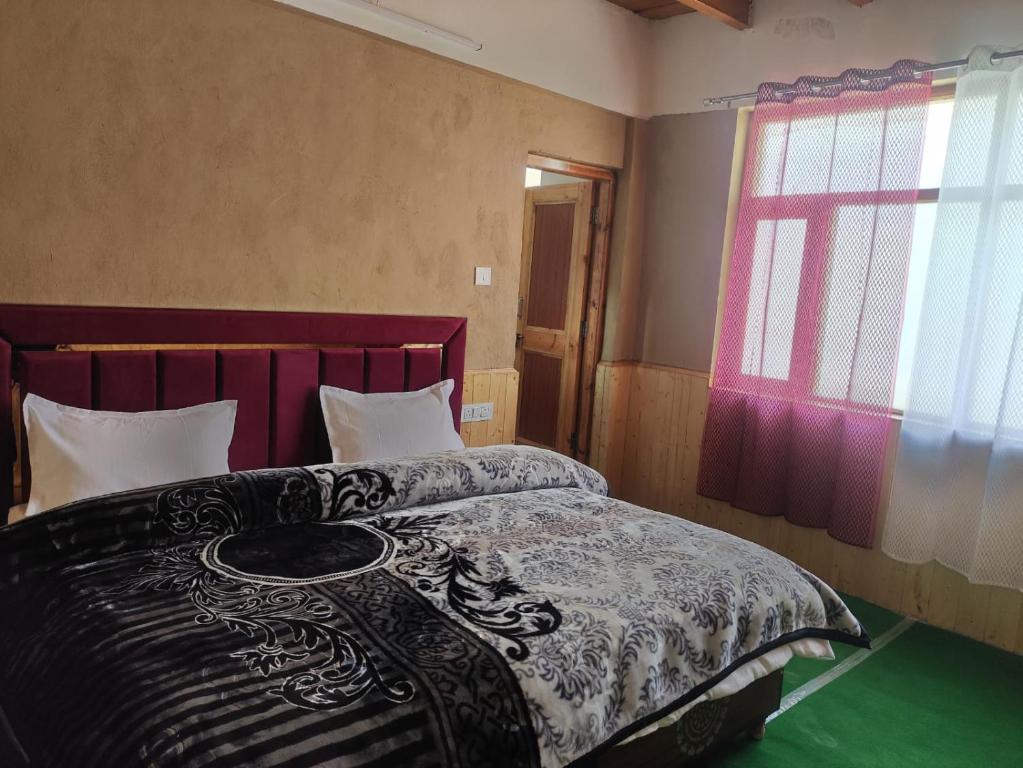 a bedroom with a bed with a black and white comforter at Ochre Spiti in Lara