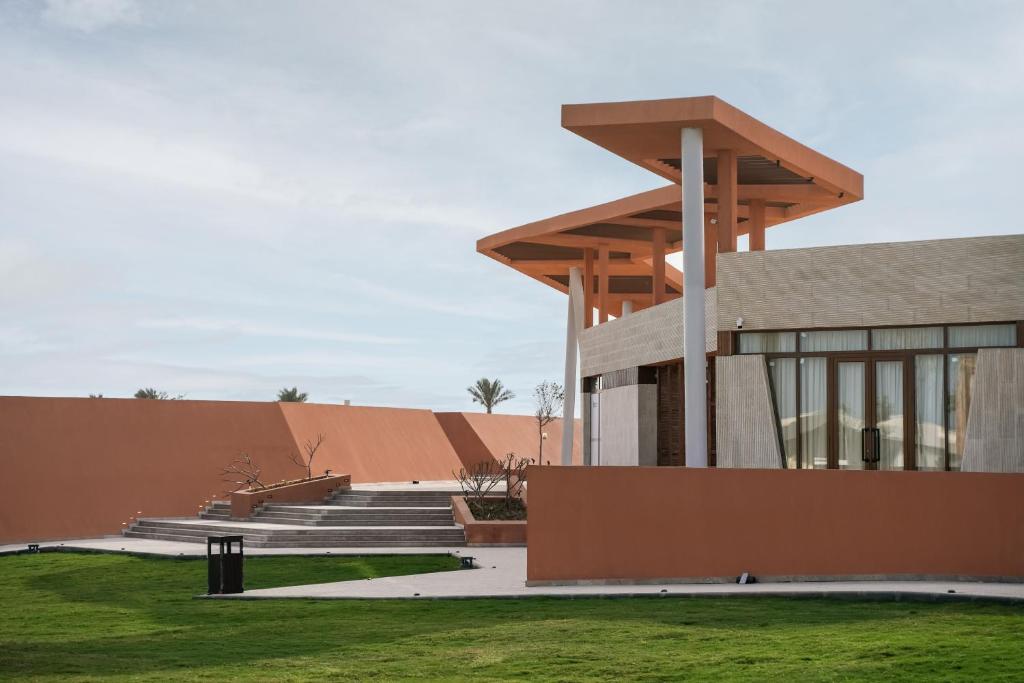 a building with concrete steps and a grass field at Good Days Habitat Soma Bay in Hurghada