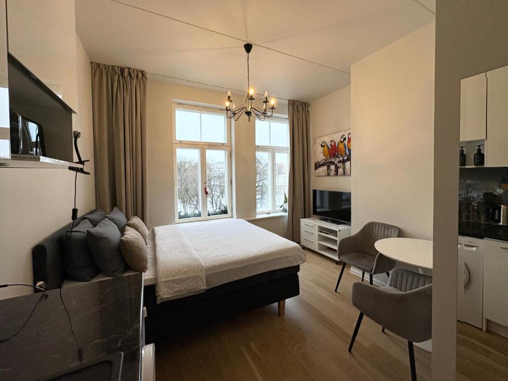 a bedroom with a bed and a table and a window at Orange Apartments Mere in Tallinn