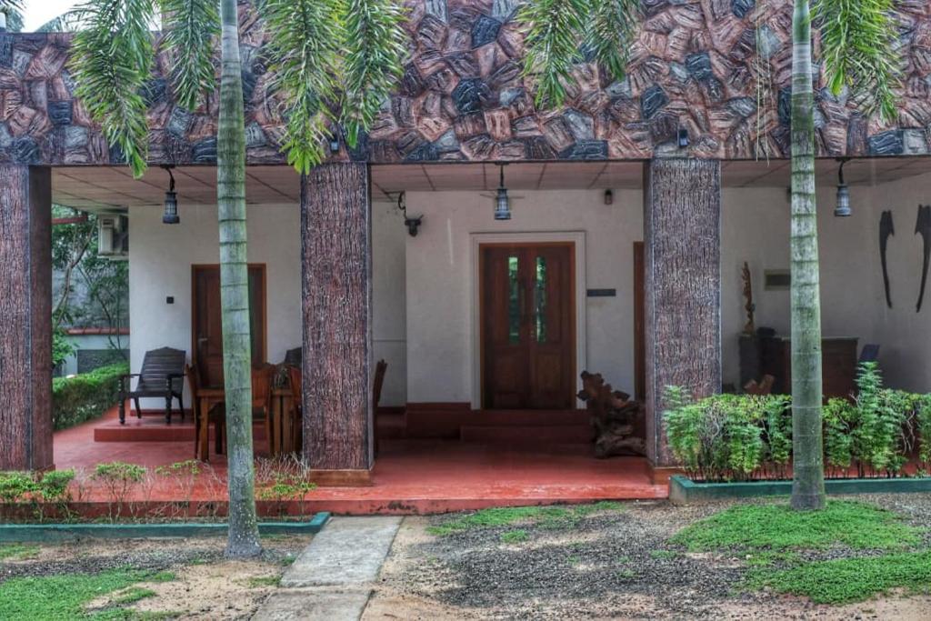 a house with a front porch with palm trees at Ceylon Luminara in Veyangoda