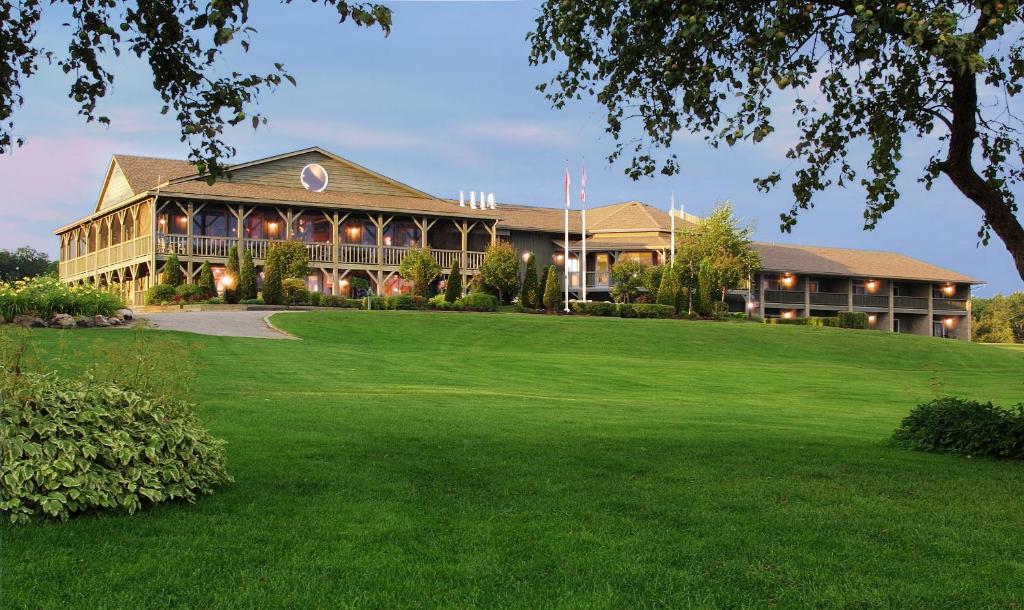 un grand bâtiment avec une grande pelouse devant lui dans l'établissement Eganridge Resort, Golf Club & Spa, à Bobcaygeon