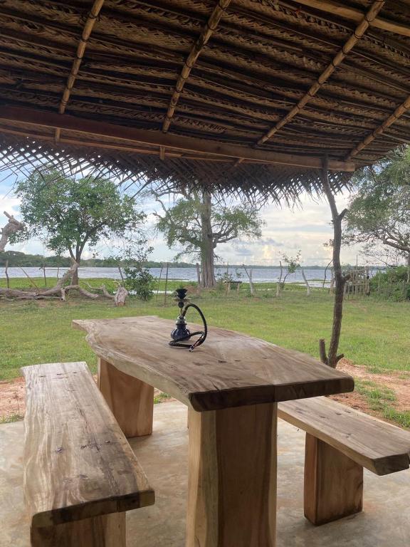 a wooden picnic table with a statue on top of it at Foresta Yala in Tissamaharama