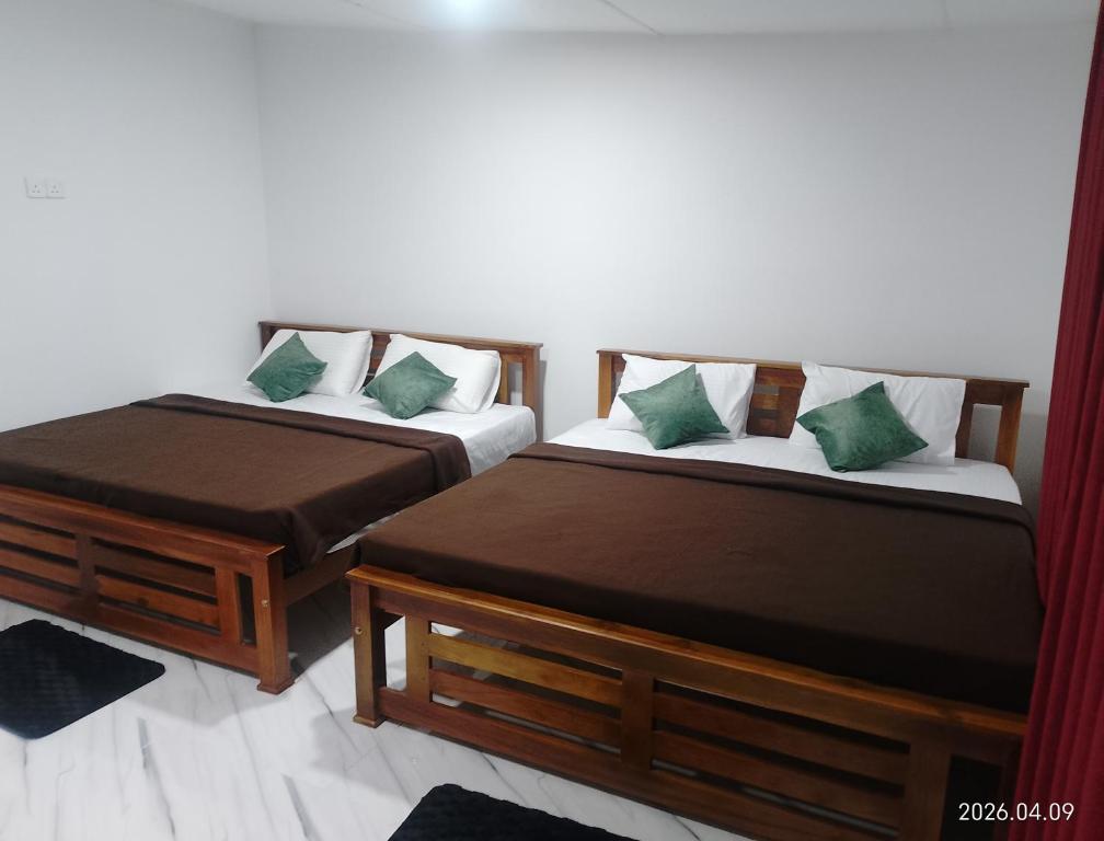 two beds sitting next to each other in a room at Tea Vibe Bungalow Malwatte in Bandarawela