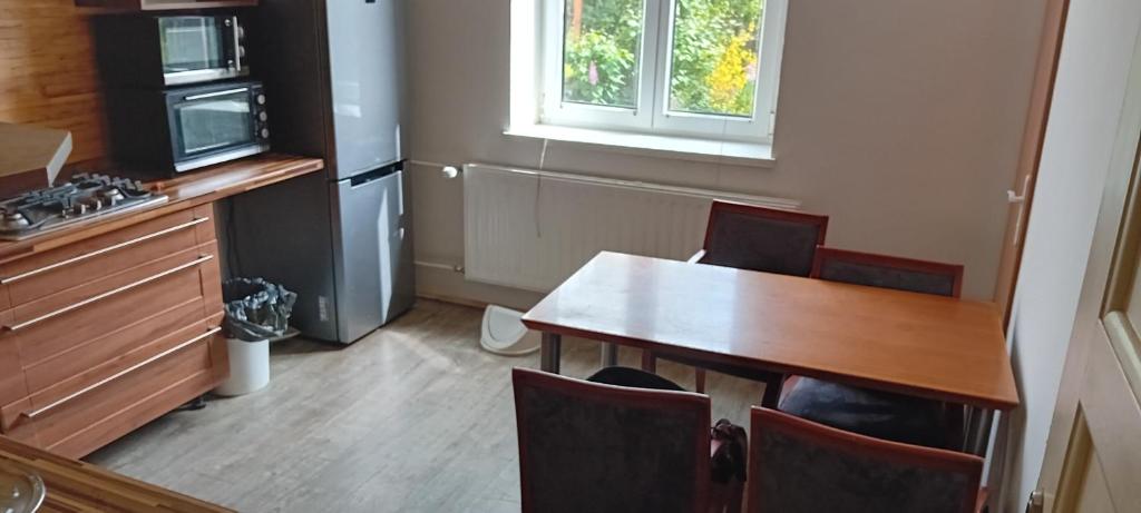 a kitchen with a table and chairs and a refrigerator at Vilem in Komárov