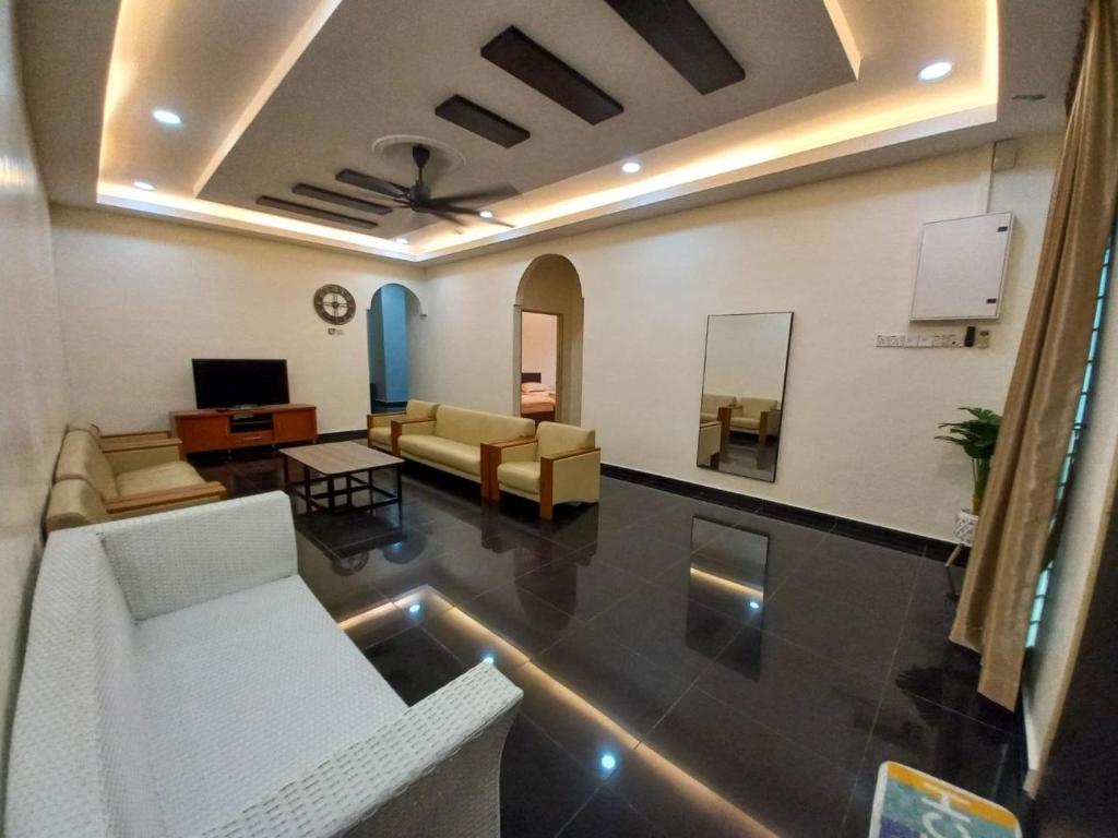 a living room with couches and a tv in a room at mulia homestay in Teluk Intan