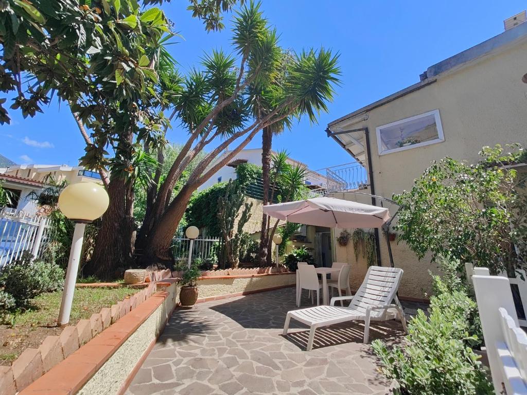 a patio with two chairs and an umbrella at La casa di Iole in Maratea