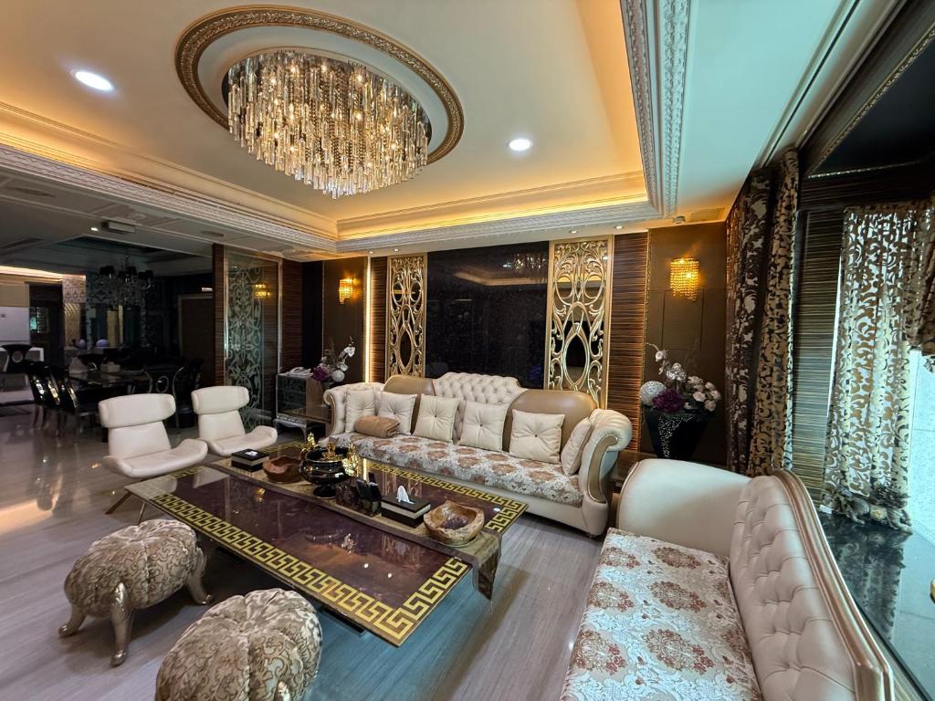 a living room with white furniture and a chandelier at 木木 Lin in Chiayi City