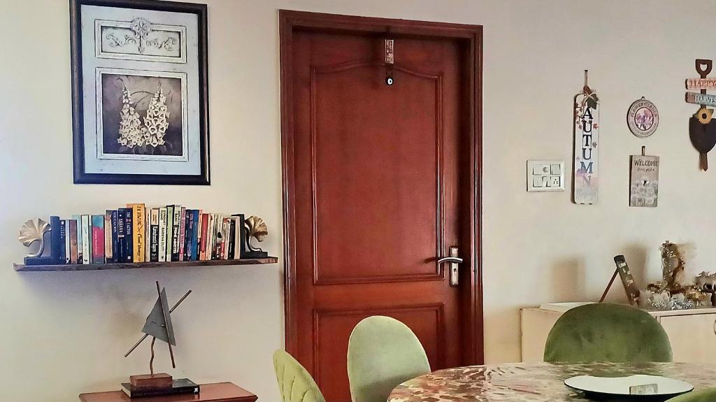 a room with a wooden door and a table with chairs at Chinar Homes Amritsar in Amritsar