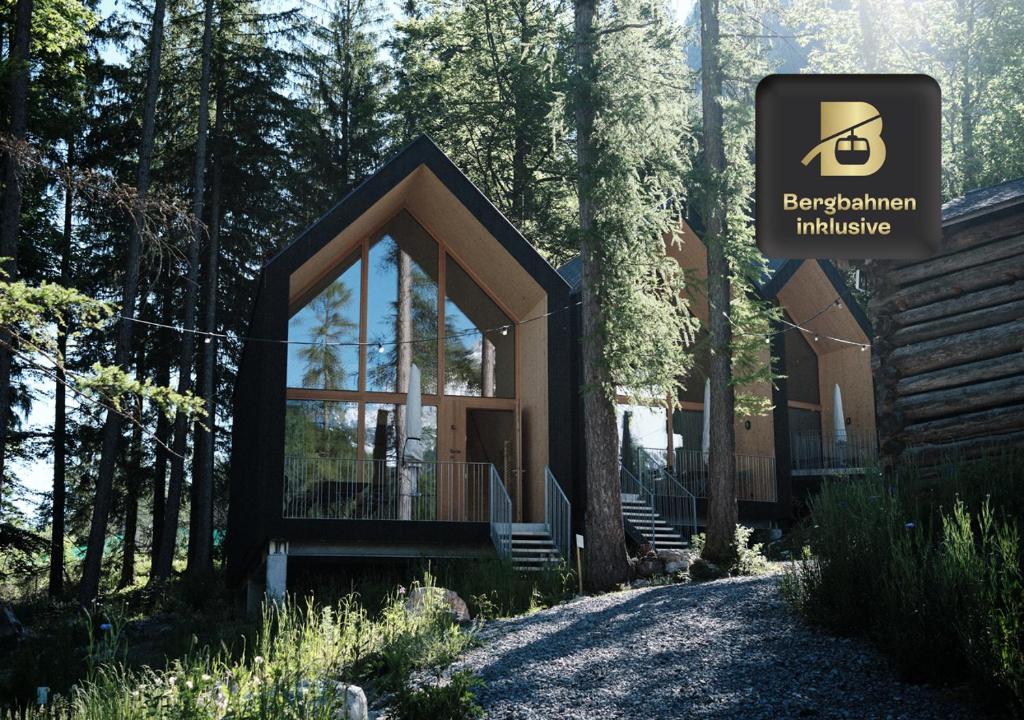 a cabin in the woods with a sign in front of it at Älmele - Waldchalets Brandnertal in Brand