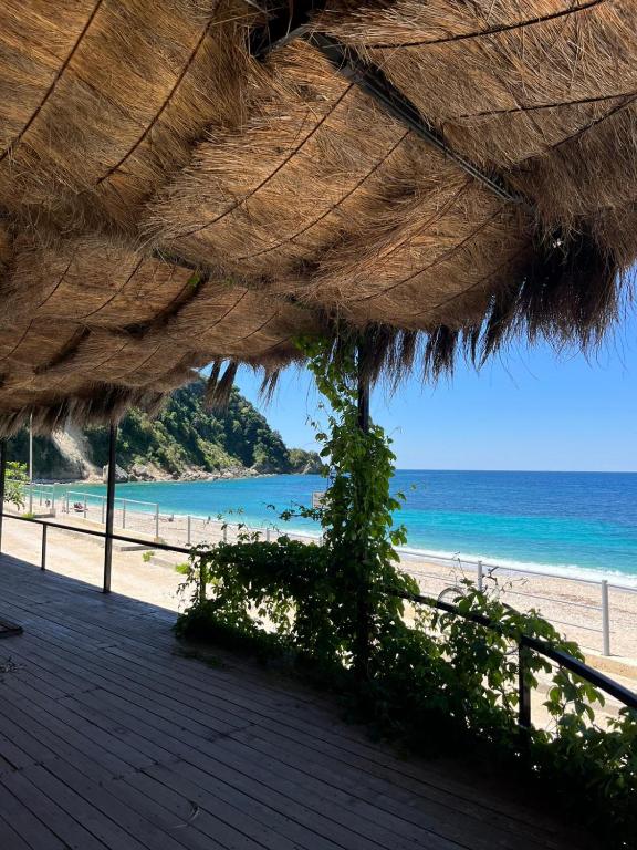 a view of a beach with a straw umbrella at Oasis on the Beach in Himare