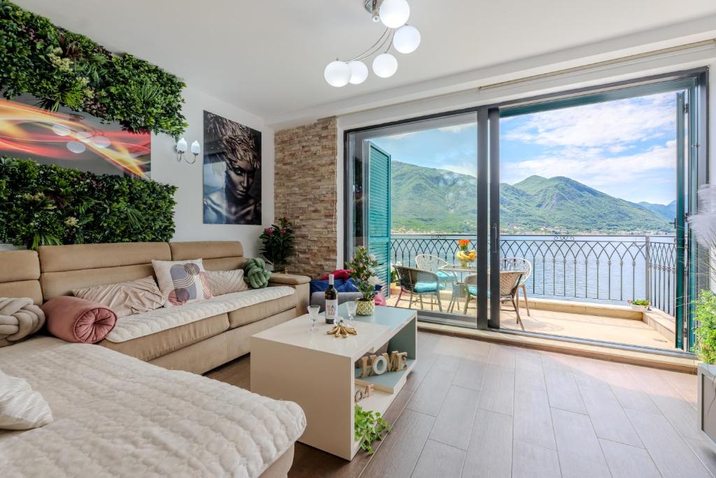 a living room with a couch and a large window at Apartment FUNNY in Kotor