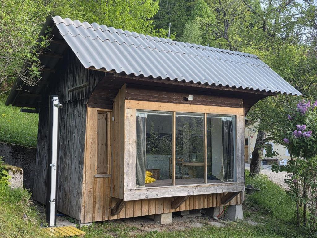 a small wooden building with a metal roof at The Ramsons - Čemaž Glamping in Železniki