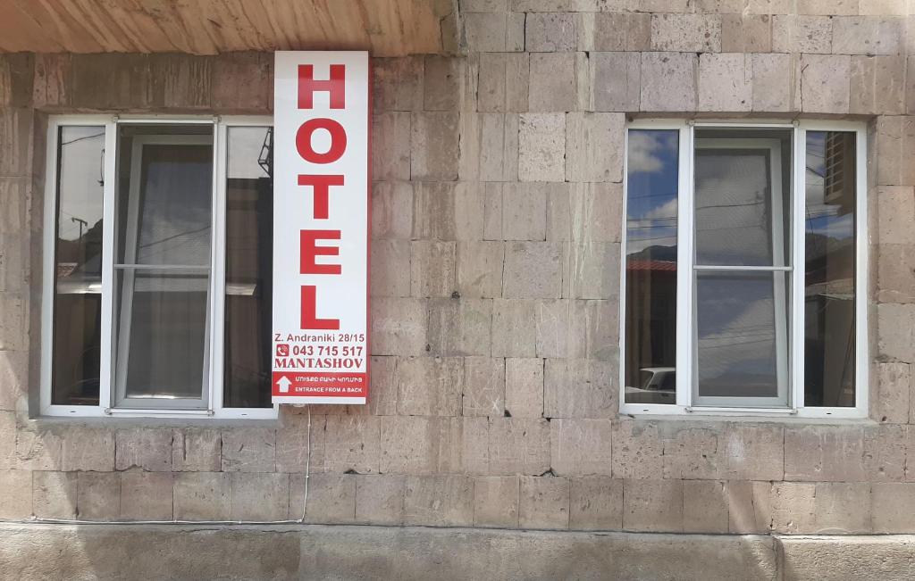 a sign on the side of a building with two windows at Hotel MANTASHOV in Meghri