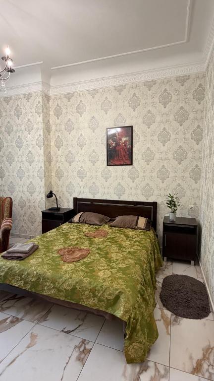 a bedroom with a bed with a green comforter at Апартаменти в парку in Uman