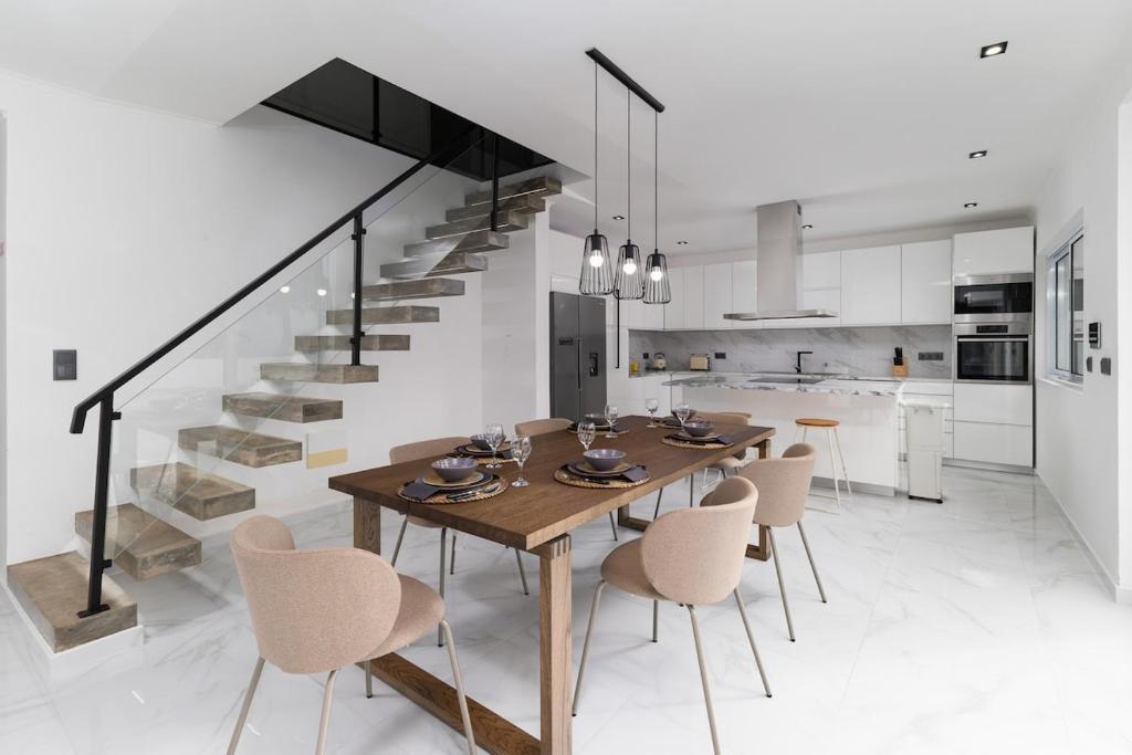 a dining room with a table and chairs and a staircase at Villa Aurora in Livramento
