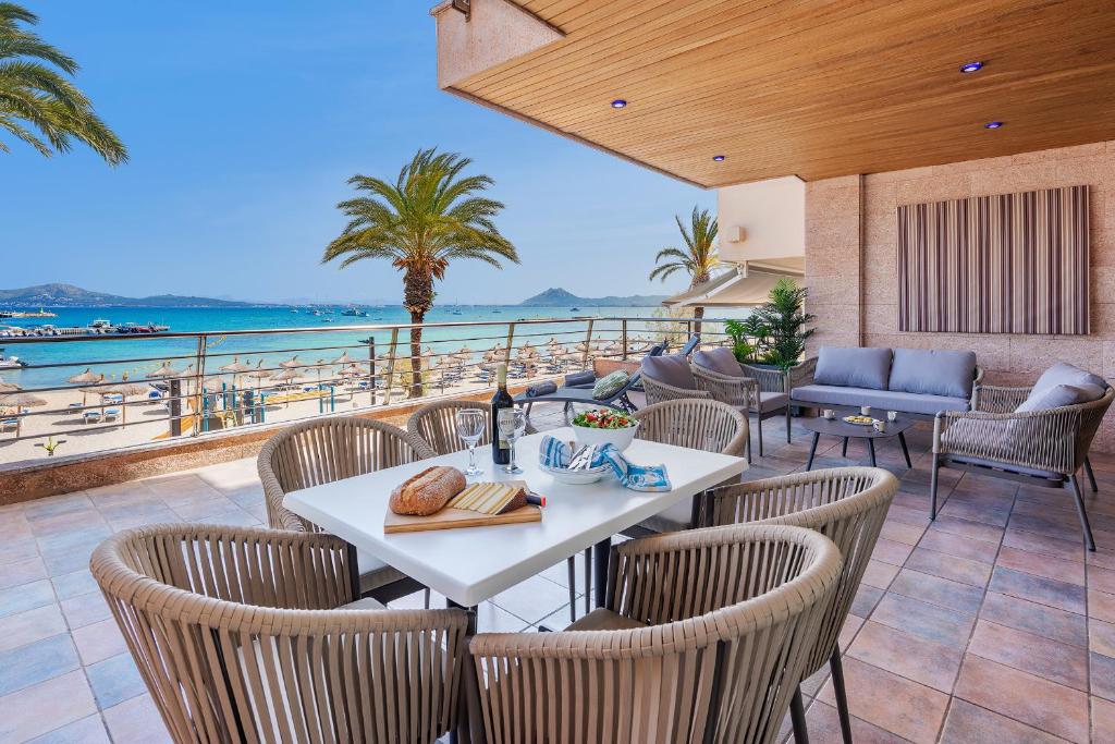 a patio with a table and chairs and the ocean at Apartment VistaMar I in Port de Pollensa