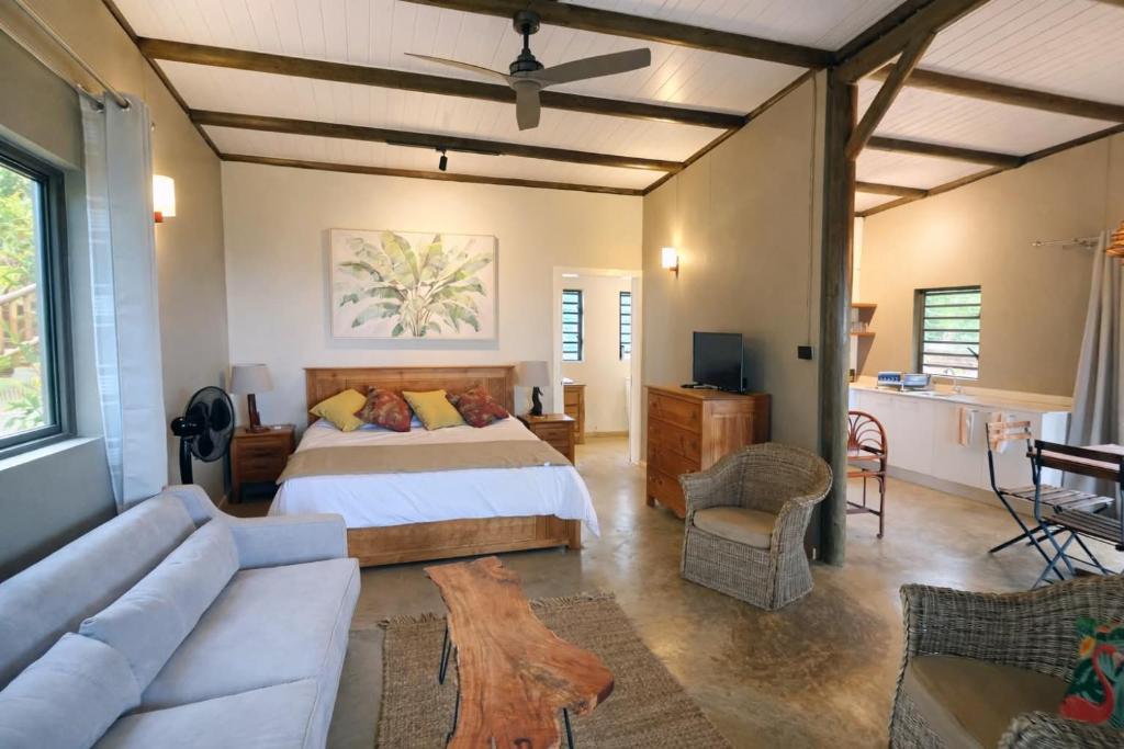 a bedroom with a bed and a couch at Terganic Farmstay in Grand Sable