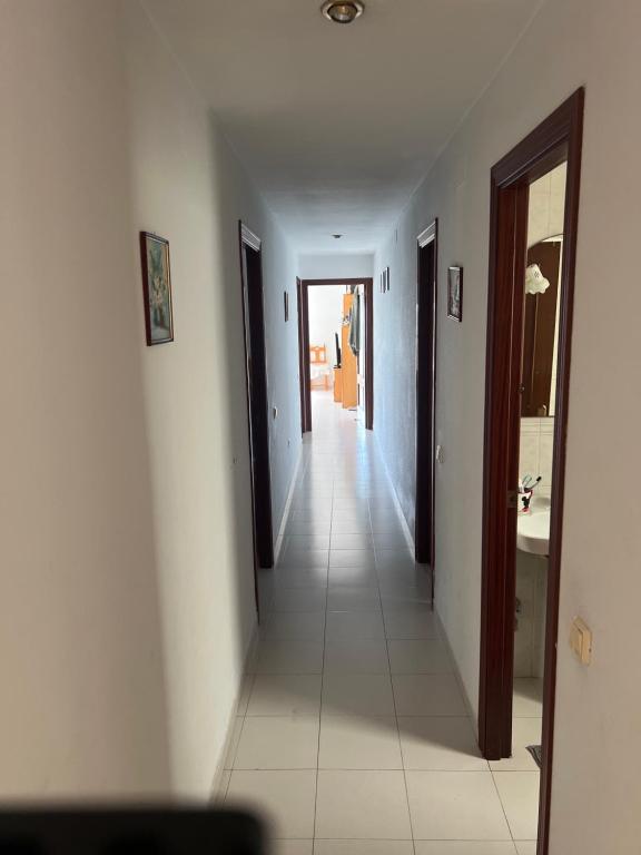 a hallway with white walls and a white tile floor at Andaluz in La Mamola