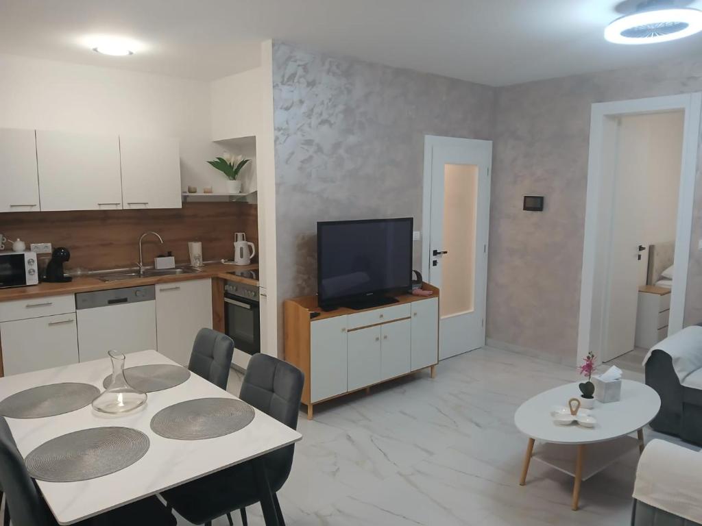 a kitchen and living room with a table and a tv at Apartman Herceg in Ljubuški