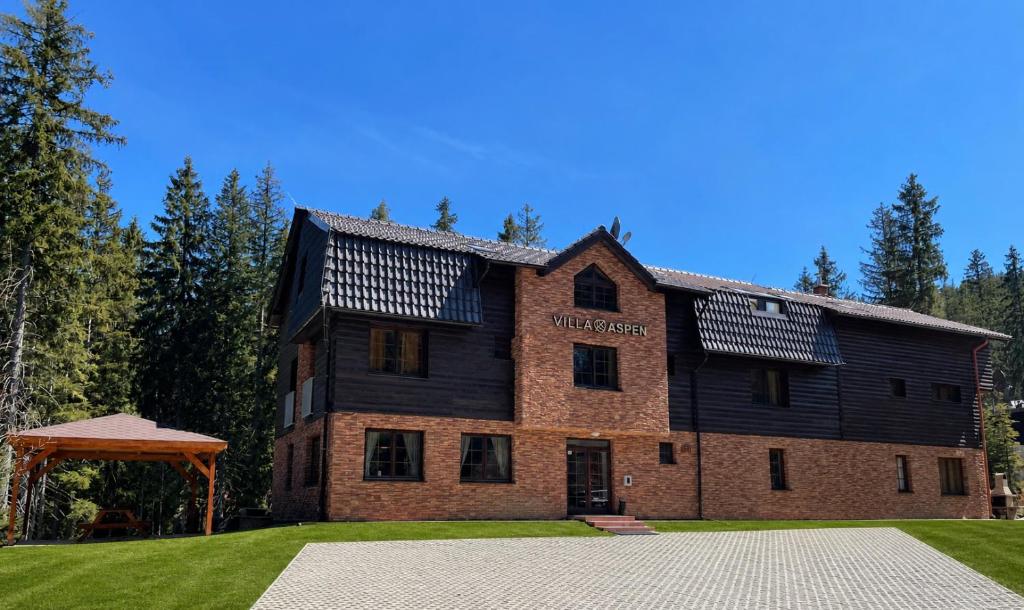 a large brick building with a sign on it at Villa Aspen in Belá