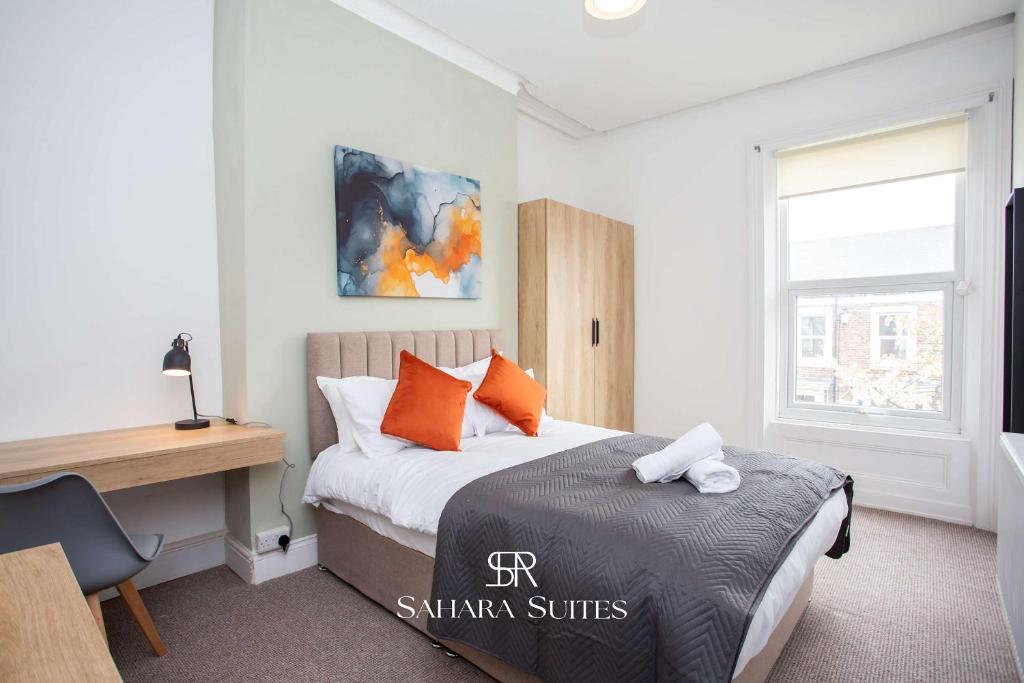 a bedroom with a bed with orange pillows and a desk at Luxury 6BR Ensuite - Contractors & Groups Stay - Parking in Sunderland