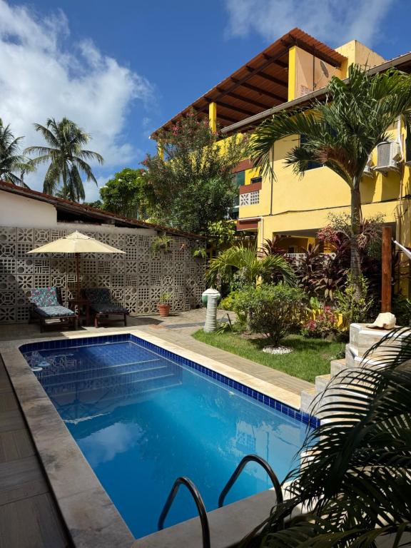 a swimming pool in front of a house at Flats Parada Obrigatoria in Maragogi