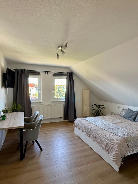 a bedroom with a bed and a desk and windows at Ferienwohnung Carla in Weißensee