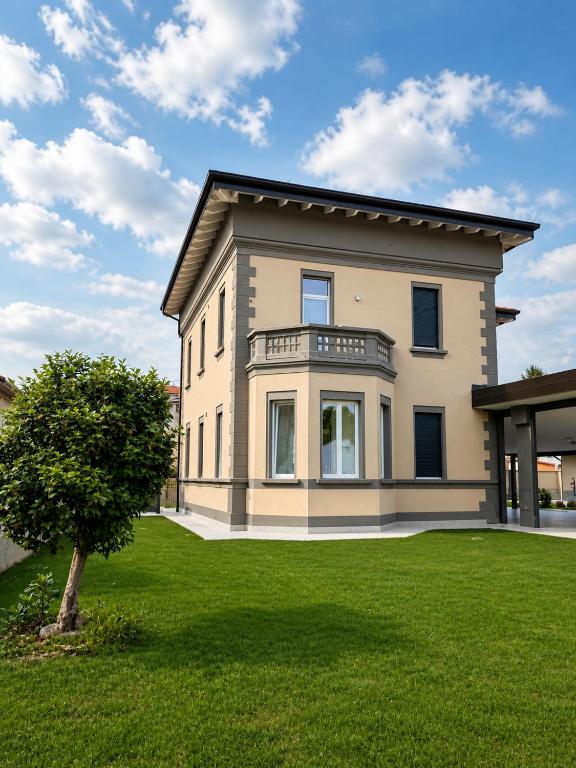 ein großes Haus mit einem Baum im Garten in der Unterkunft Mema Residence in Varallo Pombia