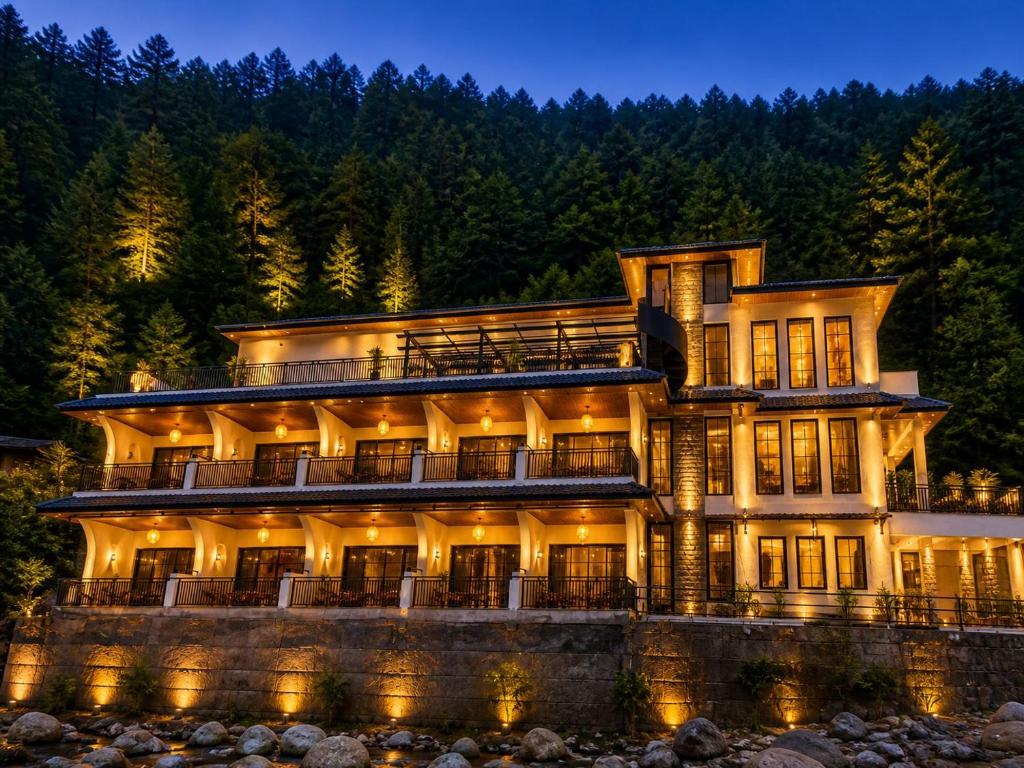 a large house on a river at night at Tiraya Luxury Riverside Hotel & Café in Gushaini