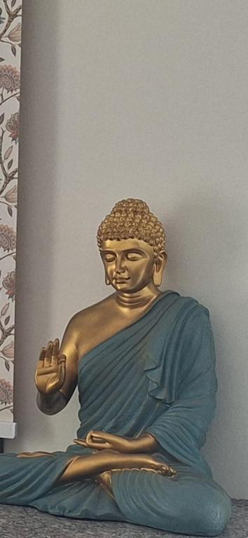 a statue of a sitting buddha on a wall at Oasis Mountain Retreat in Le Morne