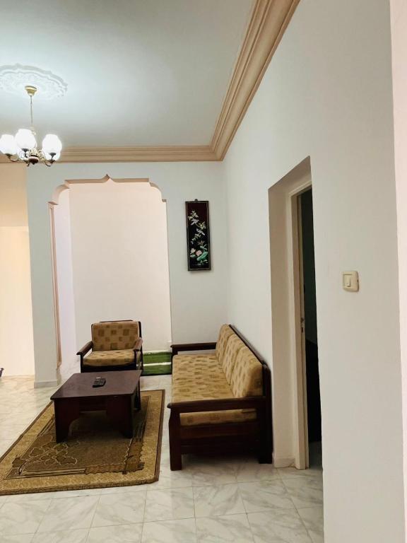 a living room with a couch and a coffee table at Appartement Al Hanine in Douz