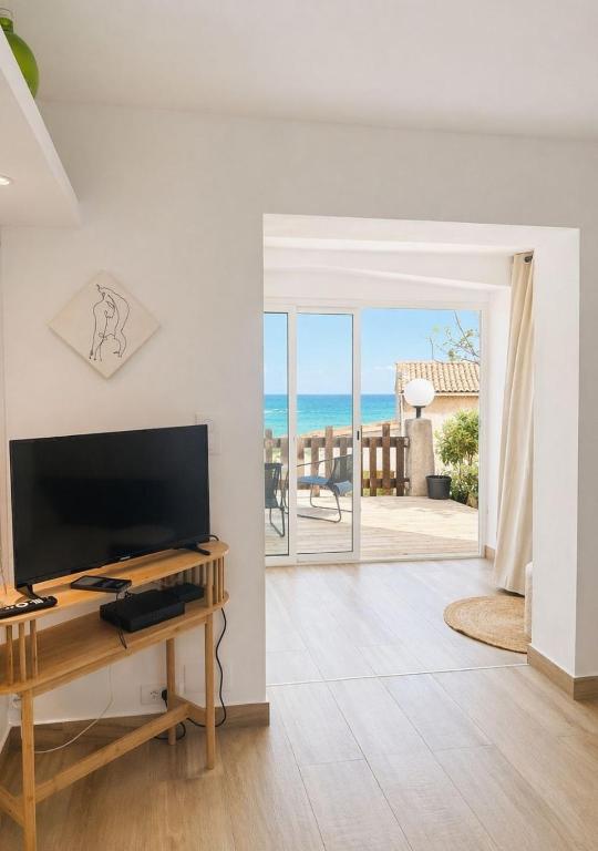 a living room with a television and a view of the ocean at Seaside Apartment in Conca