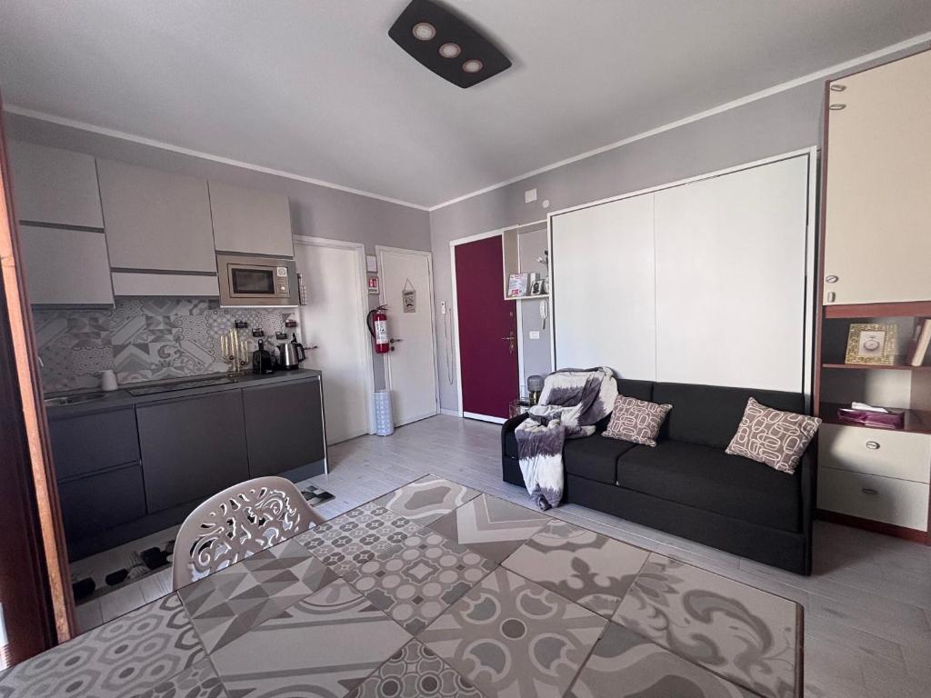 a living room with a couch and a kitchen at Studio Flat Policlinico G B Rossi in Verona