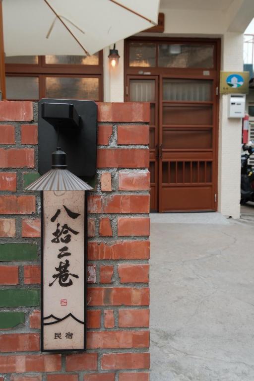a sign on a brick wall next to a door at Lane 82 Homestay in Chiayi City