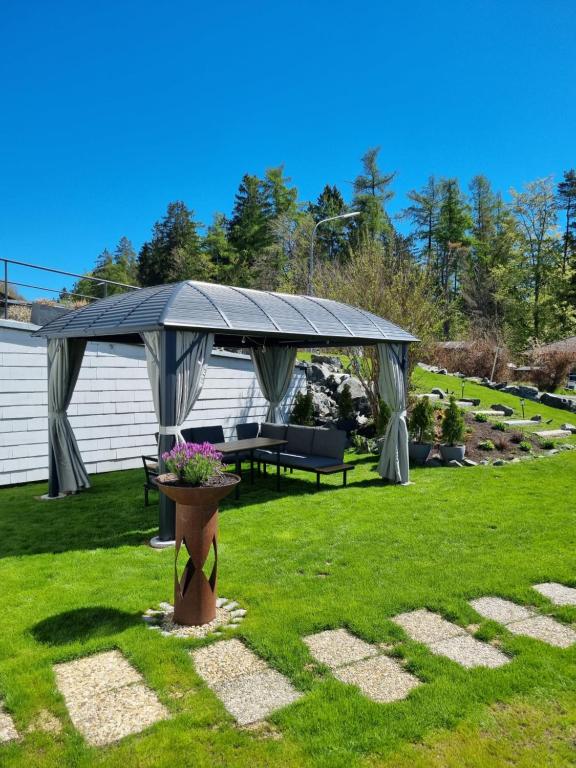 a backyard with a gazebo and a table and chairs at Gästehaus Windrose in Fichtelberg