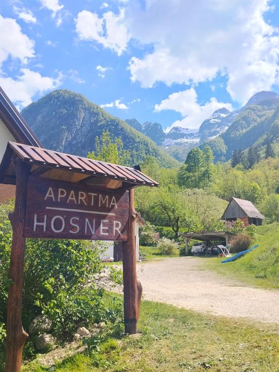 a sign for ahibina hosmer with mountains in the background at Apartment Hosner in Lepena