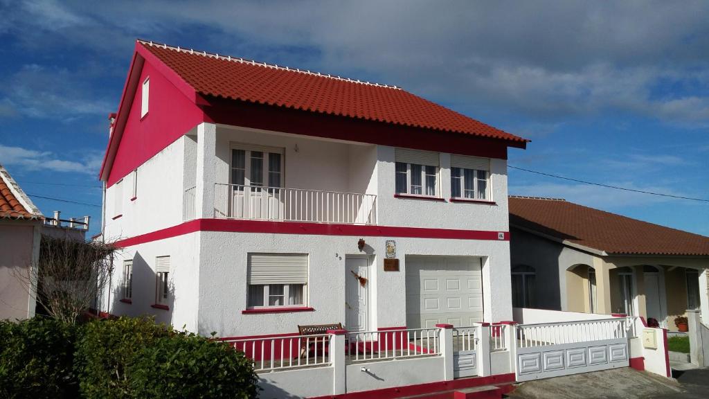 a white and red house with a red roof at Vivenda "Porto de Abrigo" in Biscoitos