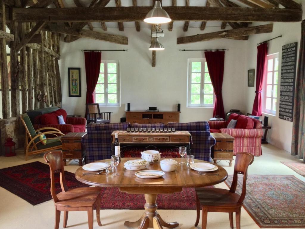 a living room with a table and a couch at Pion La Grange - cottage barn conversion in Castelnau-dʼAuzan