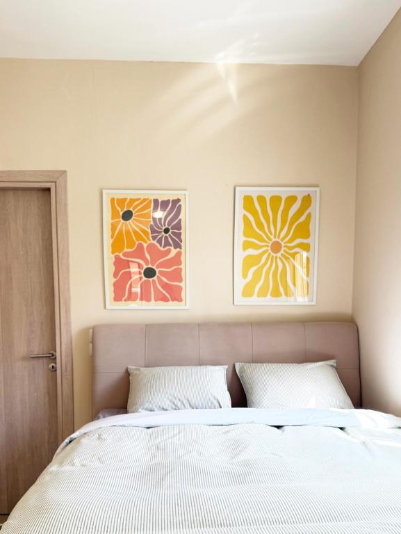 a bedroom with a bed and two pictures on the wall at LIV Aspropyrgos in Asprópirgos
