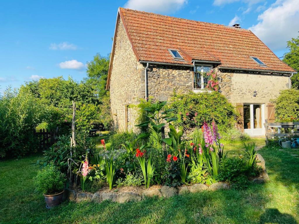 a garden in front of a house with flowers at Gîte La Ruche in Mauriac