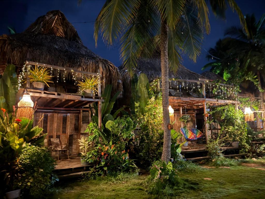 a resort with a thatched building with lights at El cielo hotel isla fuerte in Puerto Limón