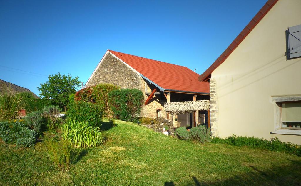 a house with a red roof and a yard at Chambres d'hôtes l'allegra in Saint-Euphrône