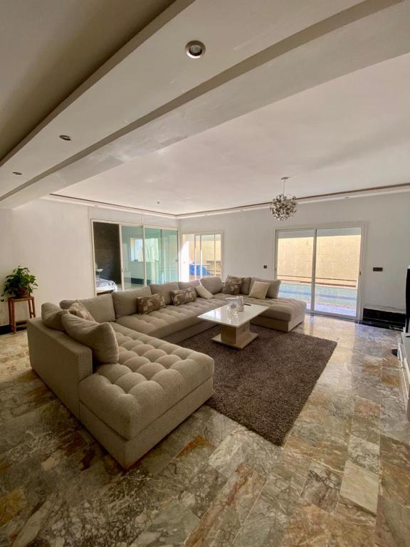 a large living room with a couch and a table at Loft a cinq minute de la plage in Temara