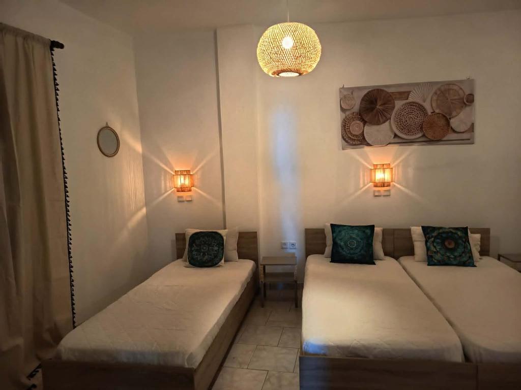a room with two beds and a light fixture at Sunshine in Maltezana