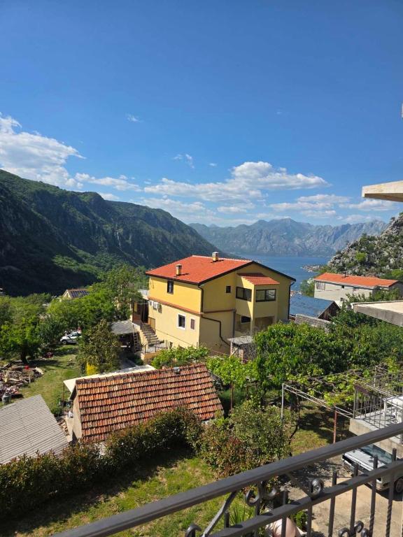a house on a hill with mountains in the background at Apartment Perović in Kotor