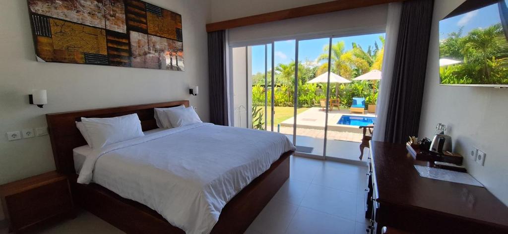 a bedroom with a bed and a view of a pool at Umah D'Kancagan in Ungasan