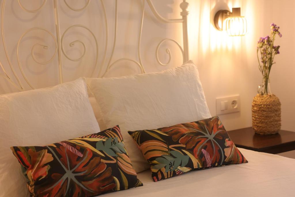 a white bed with two pillows and a headboard at Casa Rural La Canaleja in Berrocalejo