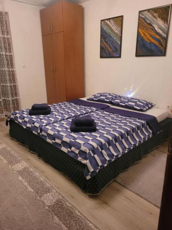 a bedroom with two beds with blue and white sheets at Hiža Guesthouse in Sarajevo