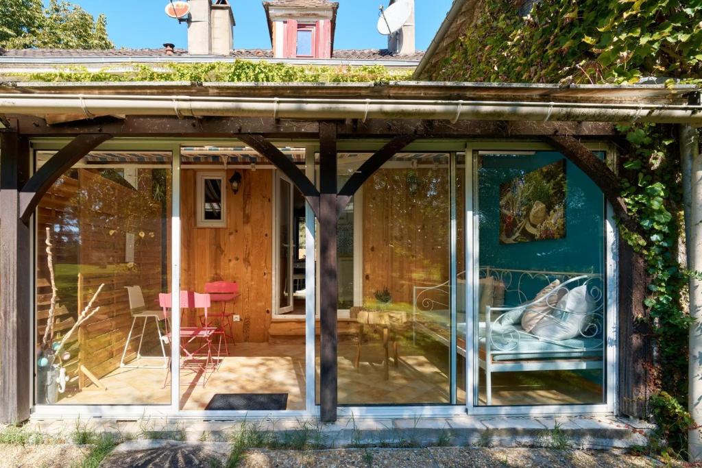a glass extension to a house with a patio at L'Envol - Oasis Ressource in Eyliac